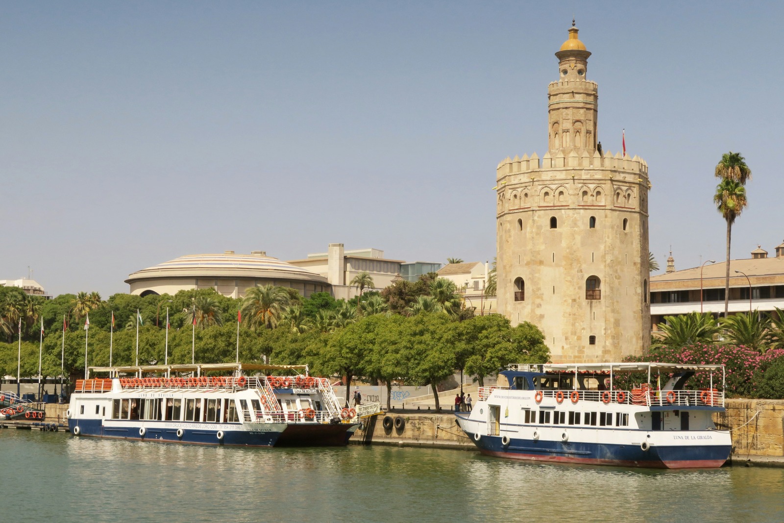 Cruceros fluviales en el muelle con el Teatro de la Maestranza al fondo