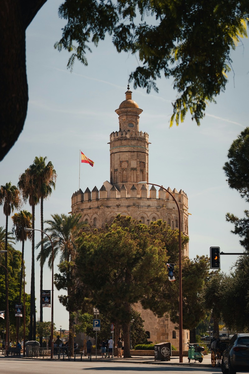 La Torre del Oro integrada en el entorno urbano, entre señales, semáforos y arboleda