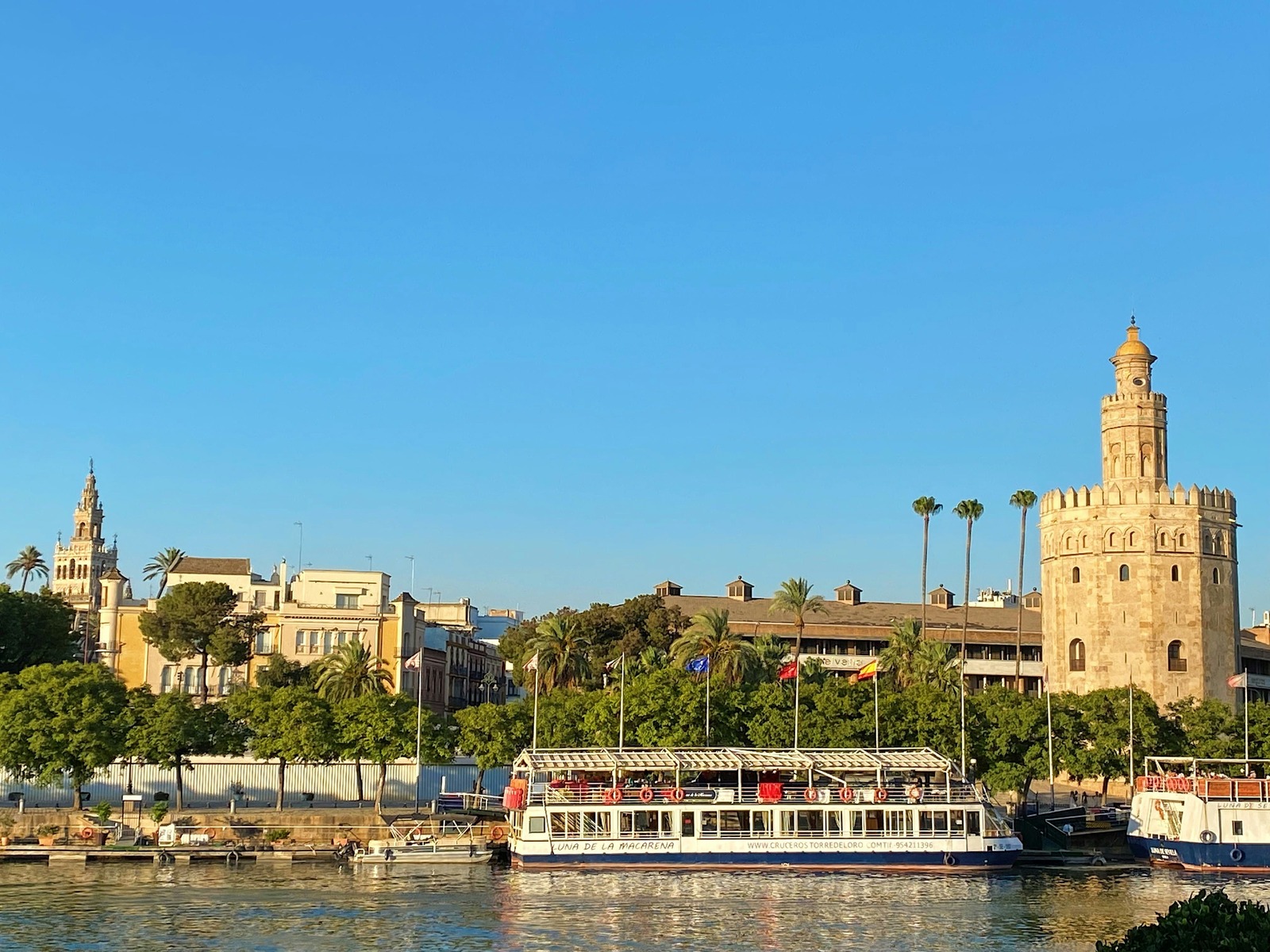 La Torre del Oro desde el río con el crucero Luna de la Macarena y la Giralda al fondo