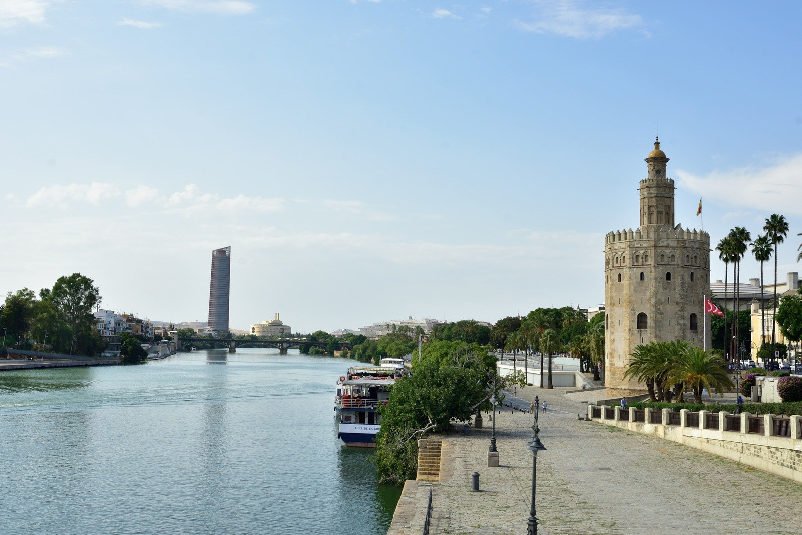 Amplia vista del Guadalquivir con el paseo fluvial, la Torre del Oro y el rascacielos Torre Sevilla